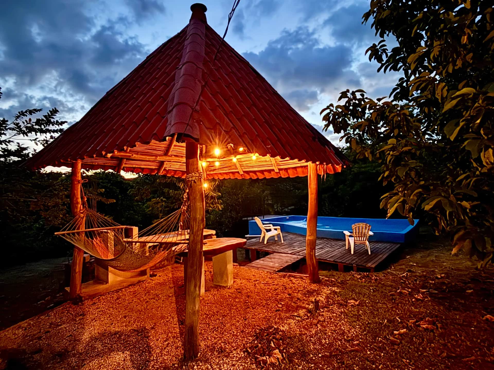 Rancho iluminado junto a la piscina al anochecer